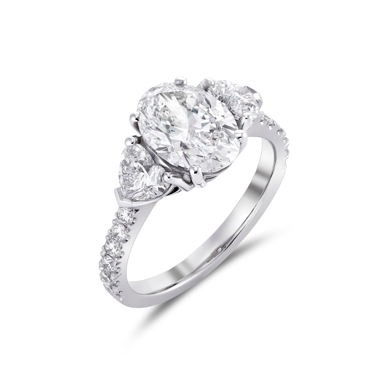Oval and heart shape diamond three stone ring with microset diamond shank in platinum, angled view